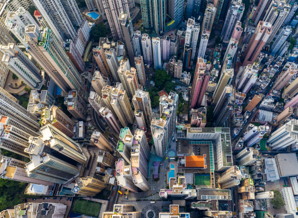 Aerial view of a dense cluster of tall skyscrapers and buildings in a city, with narrow streets and patches of greenery weaving between the structures—much like how Therefore Business Central seamlessly integrates data across your urban business landscape.